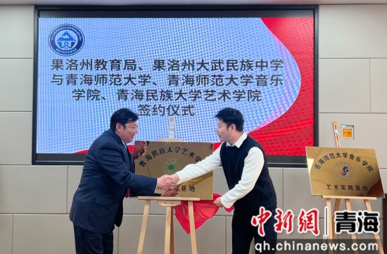 图为青海民族大学艺术学院院长杜亮（右）与果洛州大武民族中学党支部书记李晓林为基地揭牌。马铭言摄